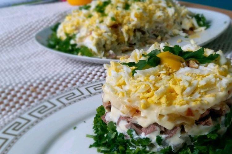 Ensalada en capas con lengua de res, pepinos y champiñones