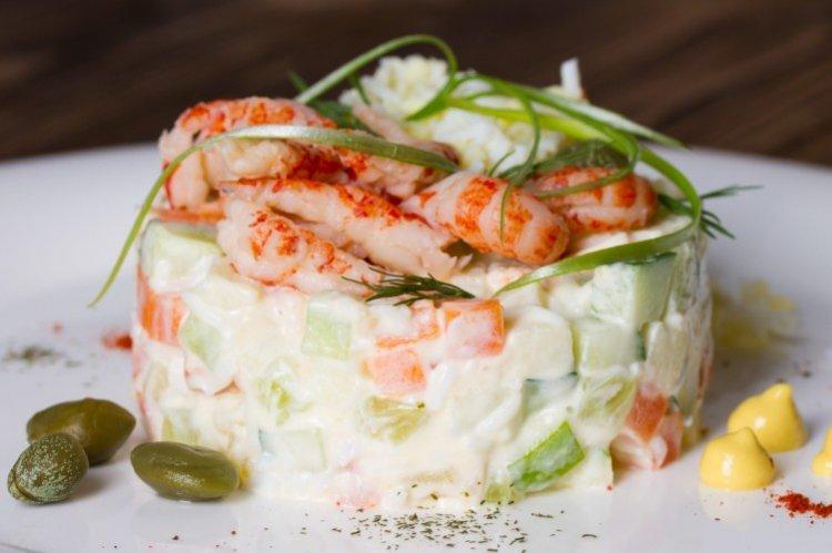 Ensalada «Olivier» con pescado y camarones gigantes
