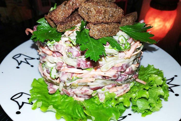 Ensalada con salchichas cocidas y picatostes