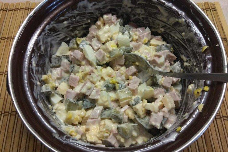 Salat aus Eiern, Salzgurken, Wurst und Erbsen