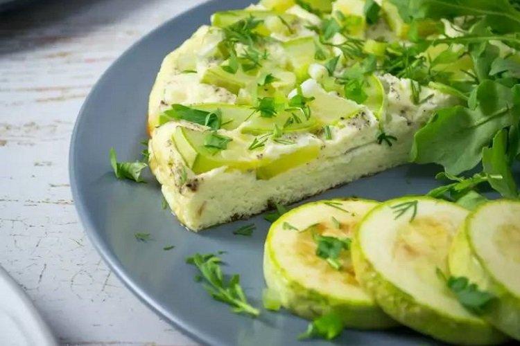 Omelett mit Zucchini und Kräutern in der Pfanne