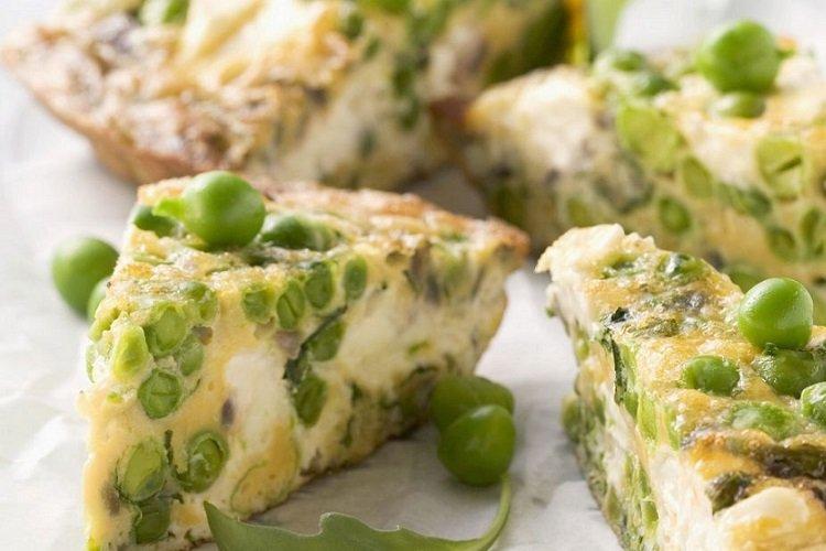 Omelett mit Zucchini und grünen Erbsen in der Pfanne