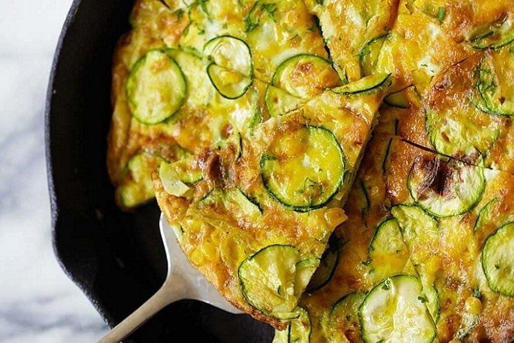 Omelett mit Zucchini und Mais in der Pfanne