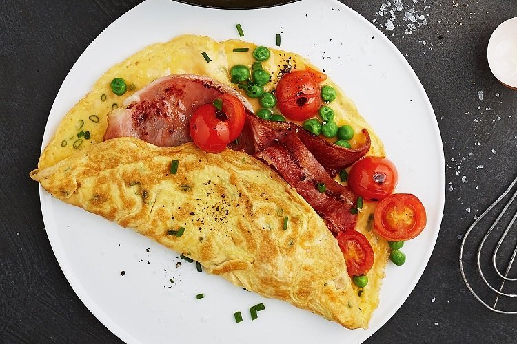 Omelet con tomates, tocino y guisantes verdes