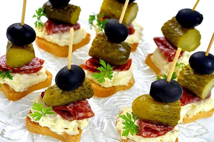 Canapés con salchicha, pepinillos encurtidos y aceitunas negras