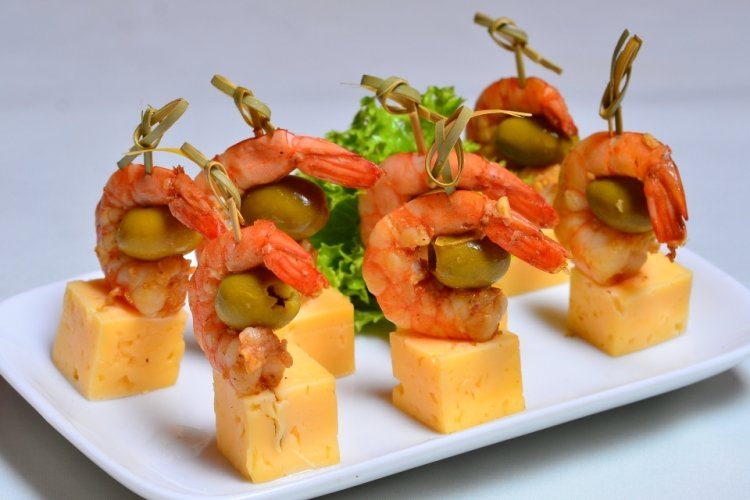 Canapés de camarones tigre, aceitunas y queso