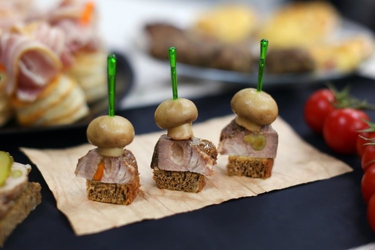 Canapés de champiñones marinados, carne asada y pan negro