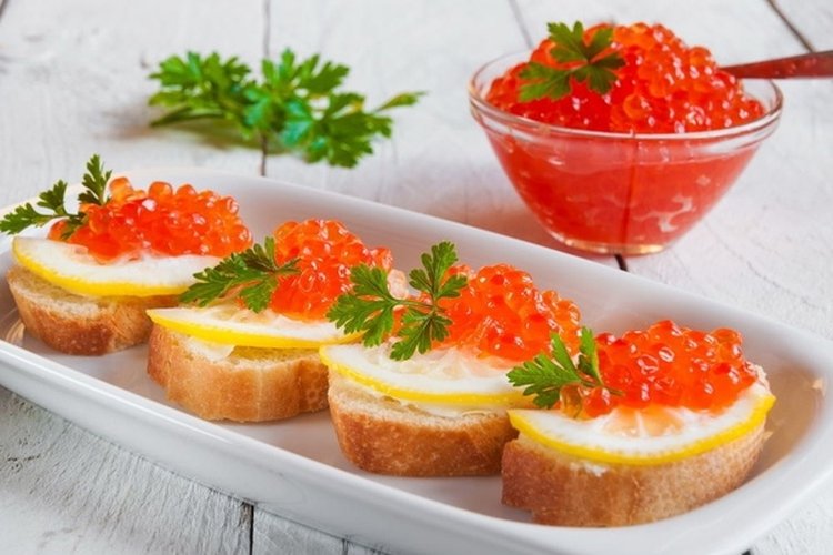 Canapés con caviar rojo, queso crema y limón