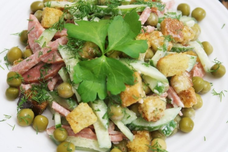 Salat mit Wurst, grünen Erbsen und Croutons
