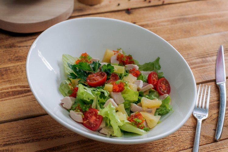 Ensalada con piña, pollo ahumado, rúcula y tomates cherry