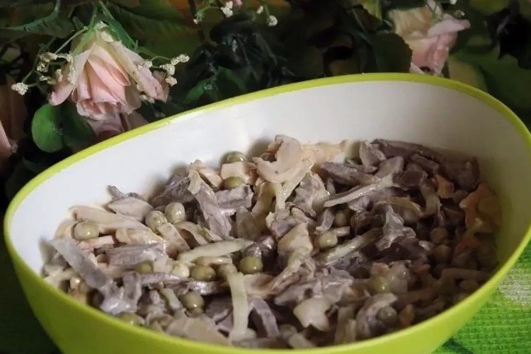 Salat mit marinierten Champignons, Schweineherz, Zwiebeln und Erbsen