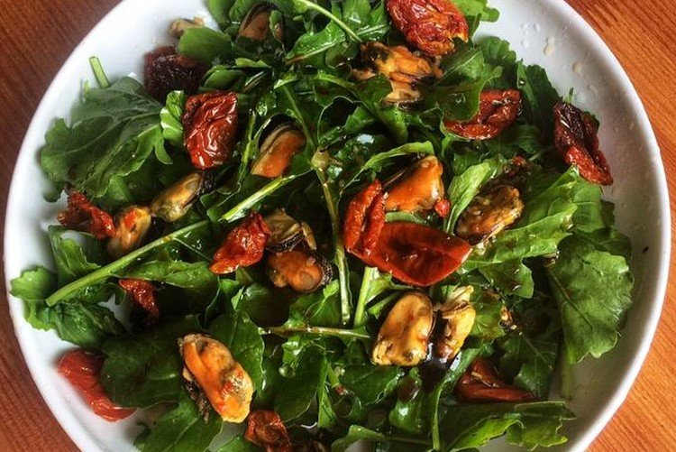 Salat mit Meeresfrüchte-Cocktail, getrockneten Tomaten und Rucola