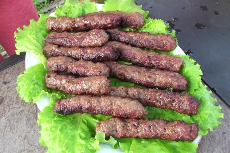 Hausgemachte Ćevapčići mit Speck