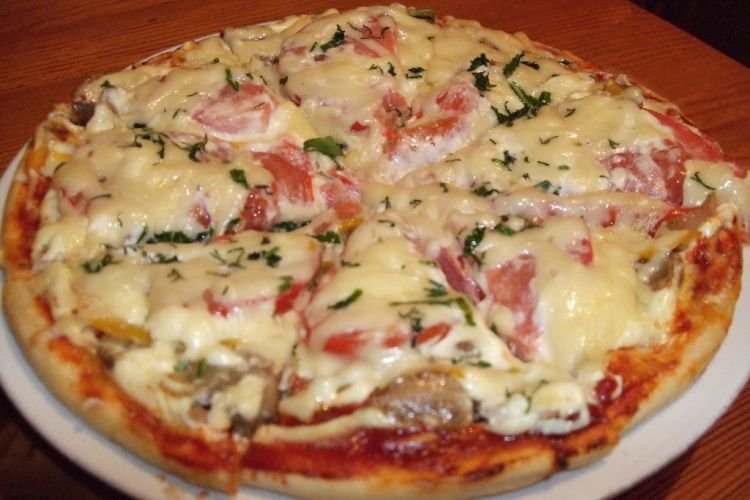 Pizza mit Wurst in der Pfanne
