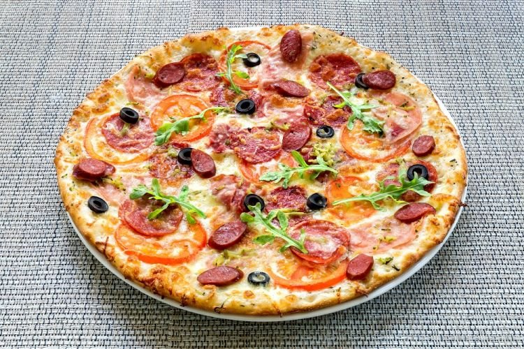 Pizza mit Wurst, Oliven und schwarzen Oliven
