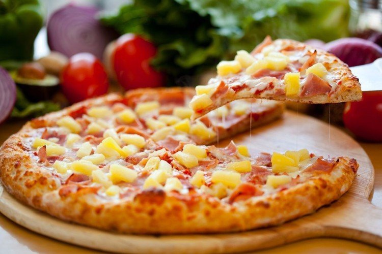 Pizza mit Ananas auf dünnem Teig