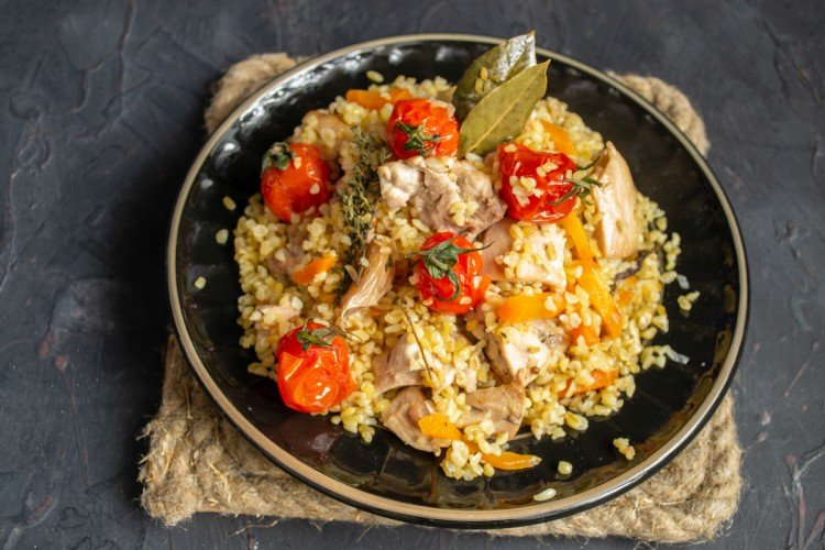 Pilaw mit Huhn und Tomaten in der Pfanne