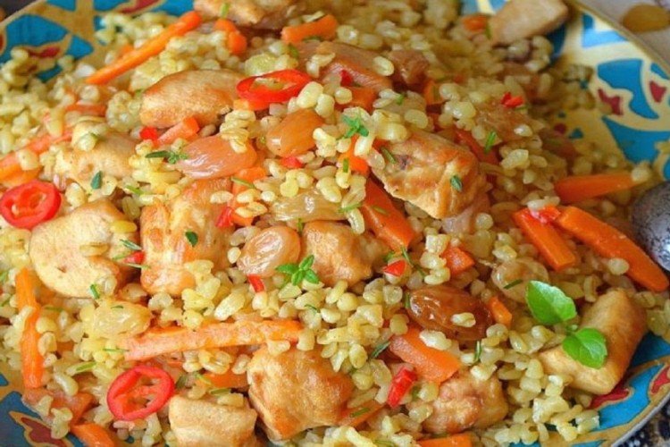 Pilaw mit Huhn und Rosinen in der Pfanne