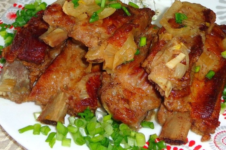 Costillas de cerdo con cebolla en sartén