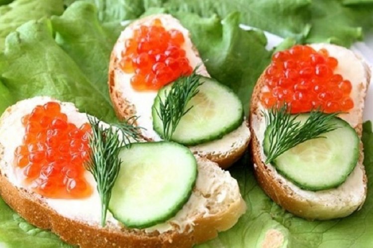 Sándwiches con queso crema, caviar rojo y pepinos