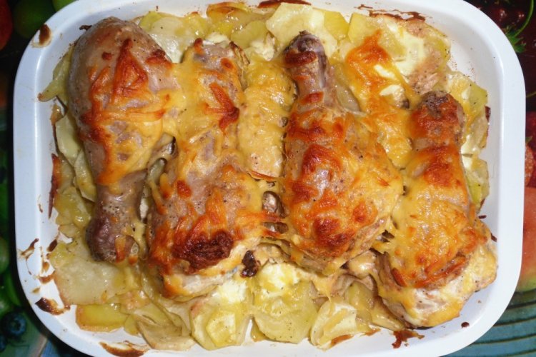 Muslos de pollo con patatas cubiertas de queso al horno