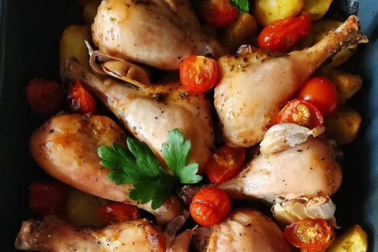 Muslos de pollo con patatas y tomates al horno
