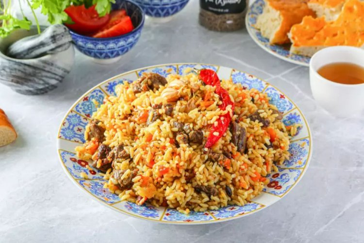 Plov mit Schweinefleisch und Gemüse im Kasan über dem Lagerfeuer