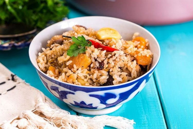 Herzhafter Plov mit Schweinefleisch und getrockneten Aprikosen im Kasan
