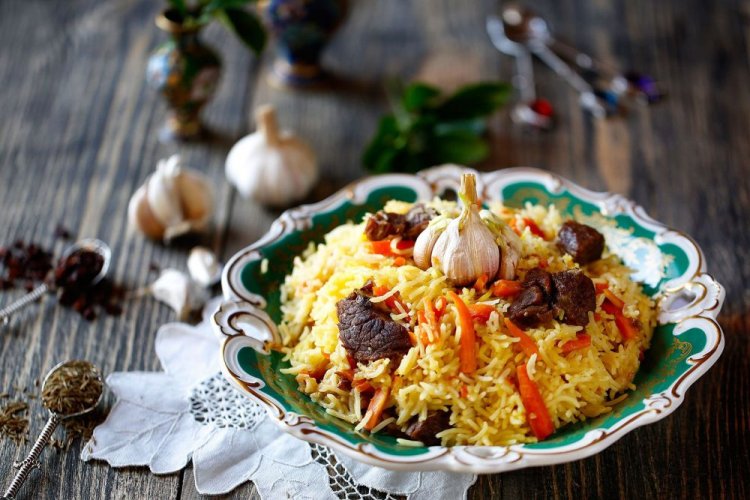 Plov über dem Lagerfeuer mit Rindfleisch und geräucherter Wurst