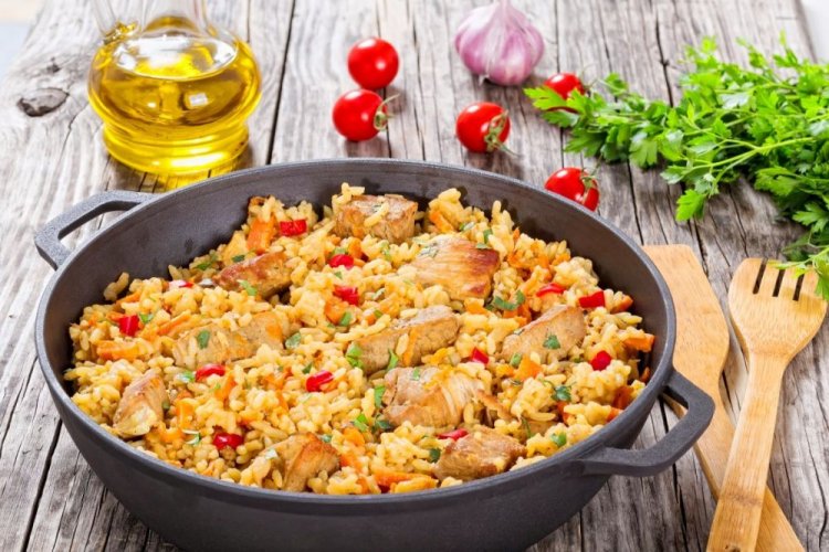 Plov mit Huhn und Tomaten über dem Lagerfeuer