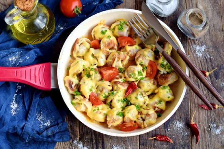 Pelmeni unter Tomaten und Käse