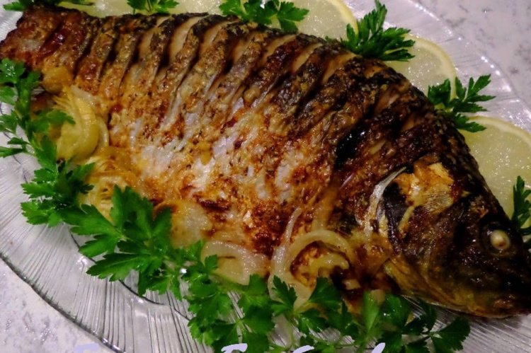 Carpa con hierbas en el horno