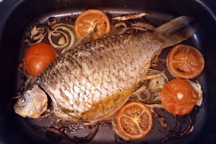 Carpa con tomates y pimiento morrón en el horno