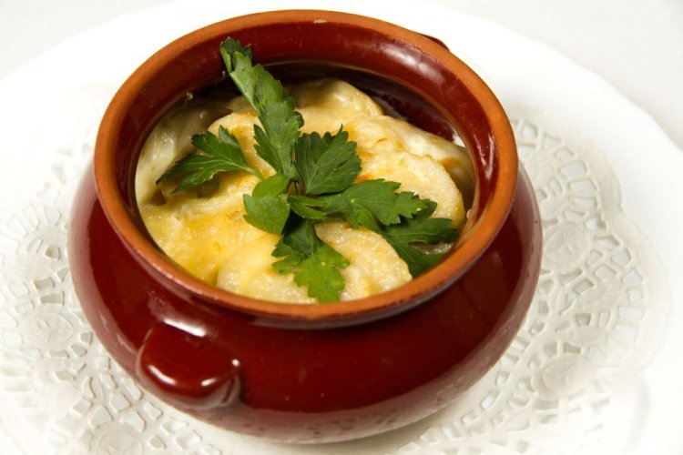 Hausgemachte Pelmeni, im Tontopf mit Käse gebacken