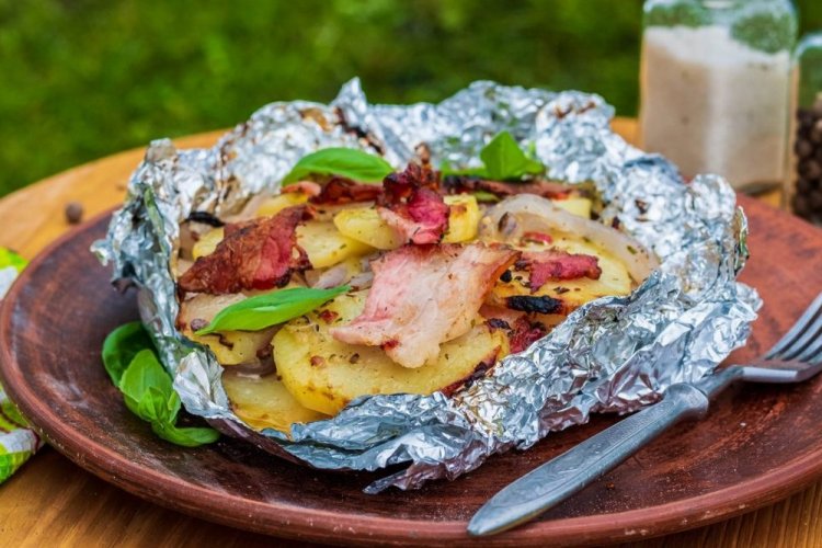 Patatas con beicon y cebolla en papel de aluminio a la parrilla