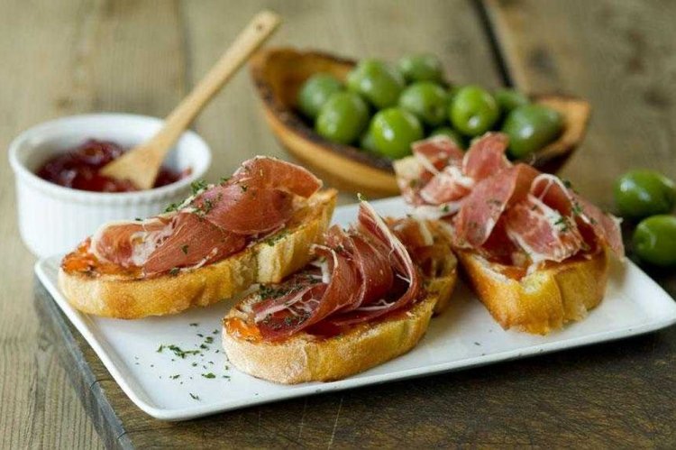 Bruschettas con jamón, tomates secos y salsa pesto