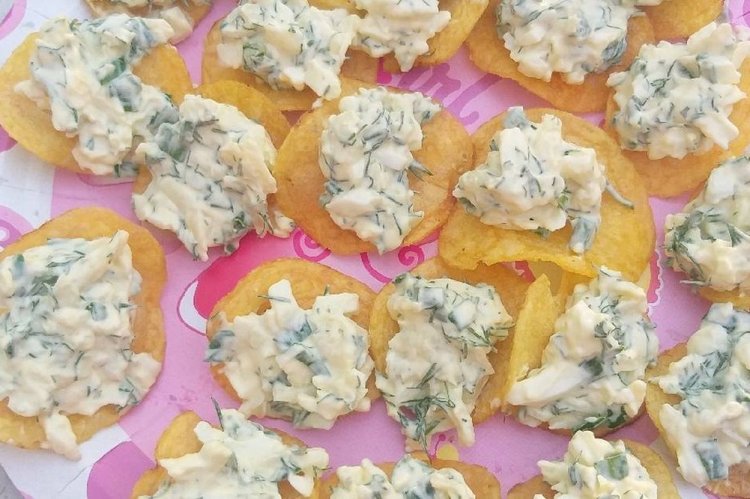 Aperitivo con queso fresco y rábano sobre patatas fritas