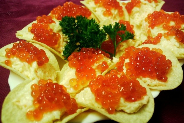 Aperitivo con caviar rojo sobre patatas fritas