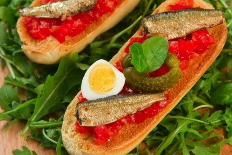 Bruschettas con espadines, tomates y huevos de codorniz