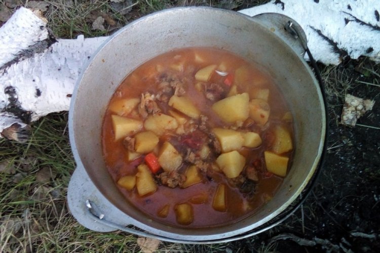 Sopa de trigo sarraceno con carne enlatada en caldero a la lumbre