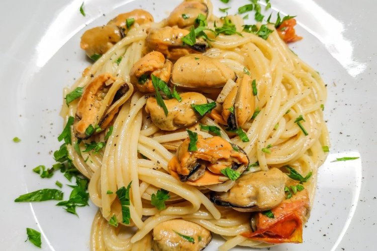 Pasta con mejillones en salsa de tomate y crema