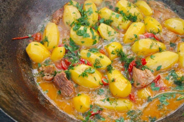 Patatas con carne y verduras en un caldero a la lumbre