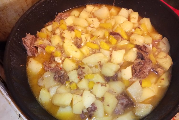 Patatas con carne enlatada en un caldero a la lumbre