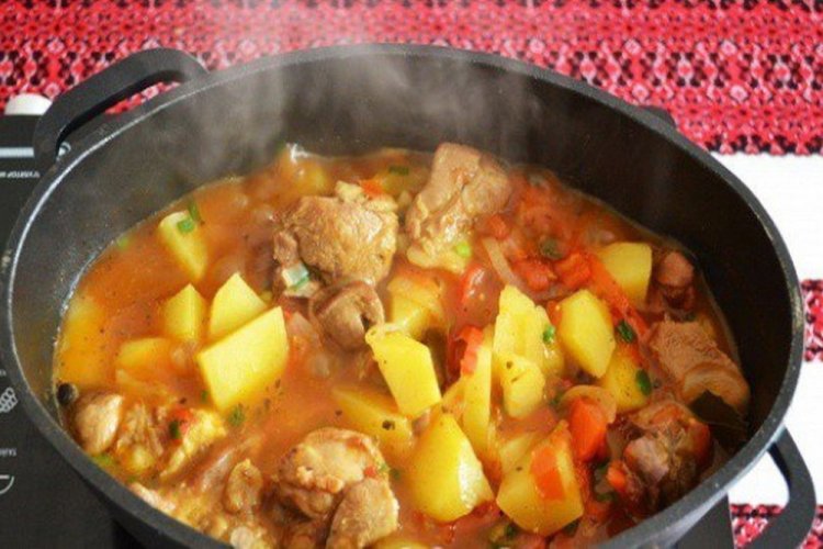 Patatas con carne y tomate en un caldero a la lumbre