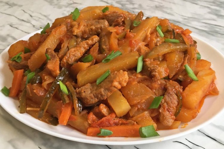 Patatas con ternera y pepinillos en un caldero a la lumbre