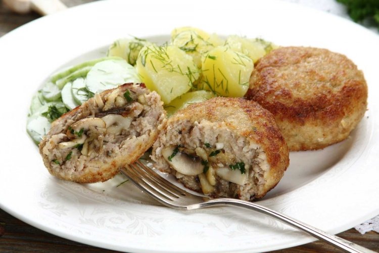 Cutlets with Mushrooms and Cheese on a Baking Sheet in the Oven