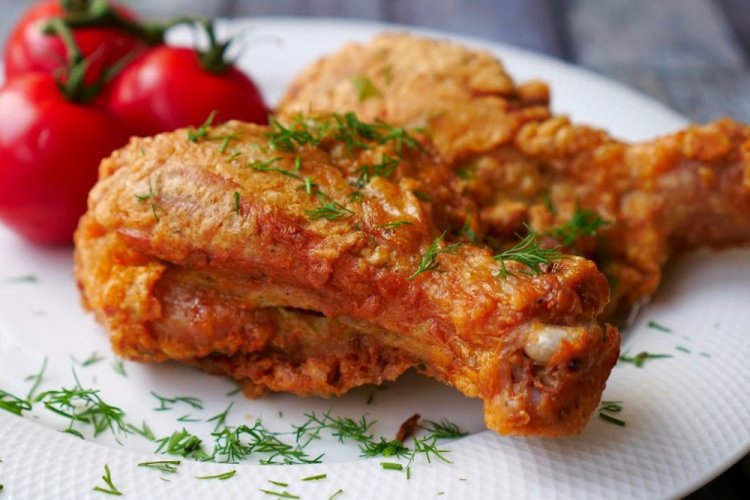 Muslos de pollo rebozados con tomate en sartén