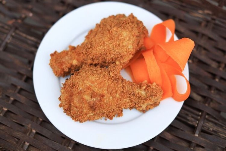 Muslos de pollo fritos con kétchup y empanado
