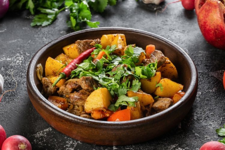 Potatoes with Meat and Vegetables on a Baking Sheet in the Oven