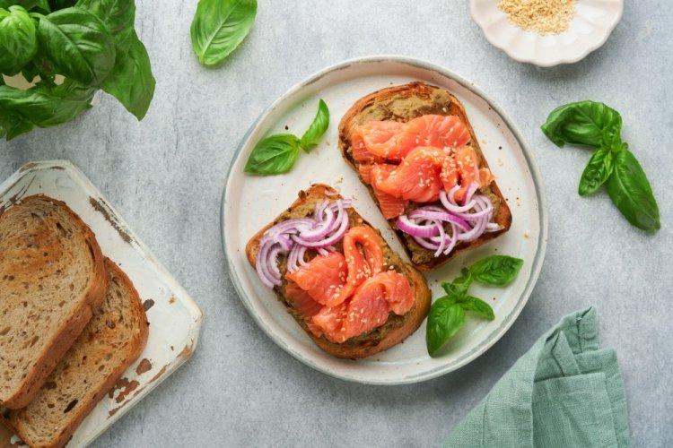 Sándwiches de pescado rojo, mantequilla y cebolla encurtida